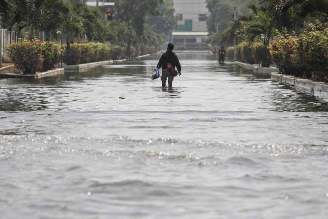 Sejumlah kendaraan yang melintas di genangan banjir rob di kawasan pasar ikan Pelabuhan Muara Baru, Penjaringan, Jakarta, Selasa (7/6).
