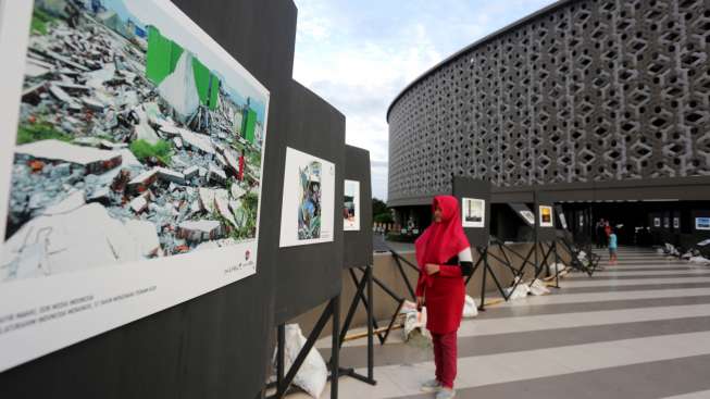 Warga menyaksikan pameran foto Silaturahmi Indonesia Menangis di Museum Tsunami, Banda Aceh, Aceh, Desember 2016. [Antara/Irwansyah Putra]