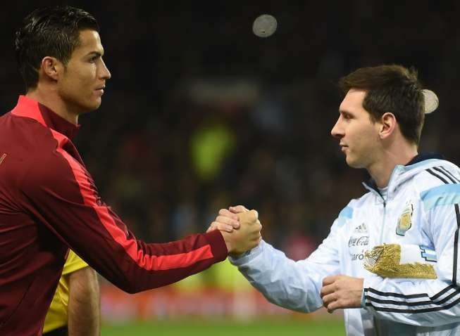 Striker Argentina Lionel Messi berjabat tangan dengan bintang Portugal Cristiano Ronaldo dalam laga persahabatan. PAUL ELLIS / AFP