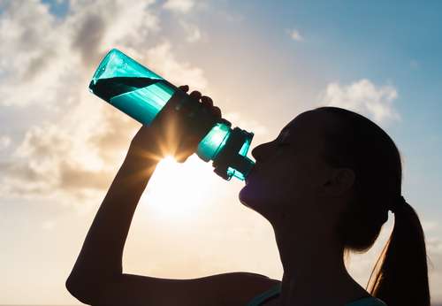 Seorang perempuan melepas dahaga dengan minum air putih. [shutterstock]