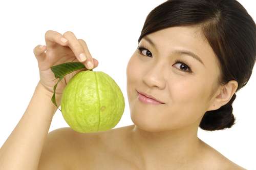 Perempuan memegang Jambu biji. (Shutterstock)