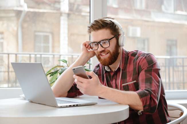 Lelaki sedang mendengarkan musik sambil bekerja. [Shutterstock]