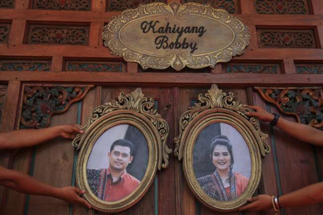 Petugas memasang foto putri Presiden Joko Widodo, Kahiyang Ayu (kanan) dengan Bobby Nasution (kiri) di Gedung Graha Saba, Solo, Jawa Tengah, Senin (6/11/2017). [ANTARA FOTO/MaulanaSurya/ama/17]