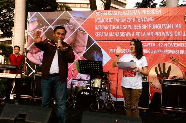 Kepala Satgas Saber Pungli, Komjen Pol Dwi Priyatno (kedua dari kiri), di sela-sela sosialisasi Stop Pungli di momen Car Free Day di Kawasan Jalan Sudirman, Jakarta Pusat, Minggu (12/11/2017). [Suara.com/Erick Tanjung]