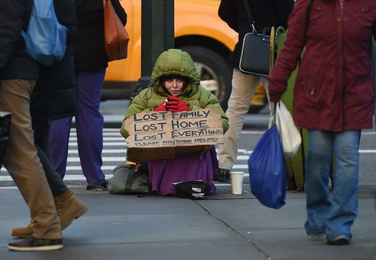 Seorang gelandangan tengah mengemis di 5th Avenue, New York, Amerika Serikat, 4 Januari 2016. [Timothy A Clary/AFP]