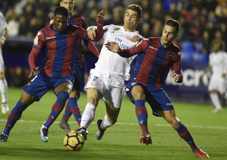 Striker Real Madrid, Cristiano Ronaldo (tengah), dikawal ketat dua pemain Levante, Jefferson Lerma (kiri) dan Rober Pier, dalam pertandingan yang berakhir imbang 2-2, Sabtu (3/2/2018). [AFP/Jose Jordan]