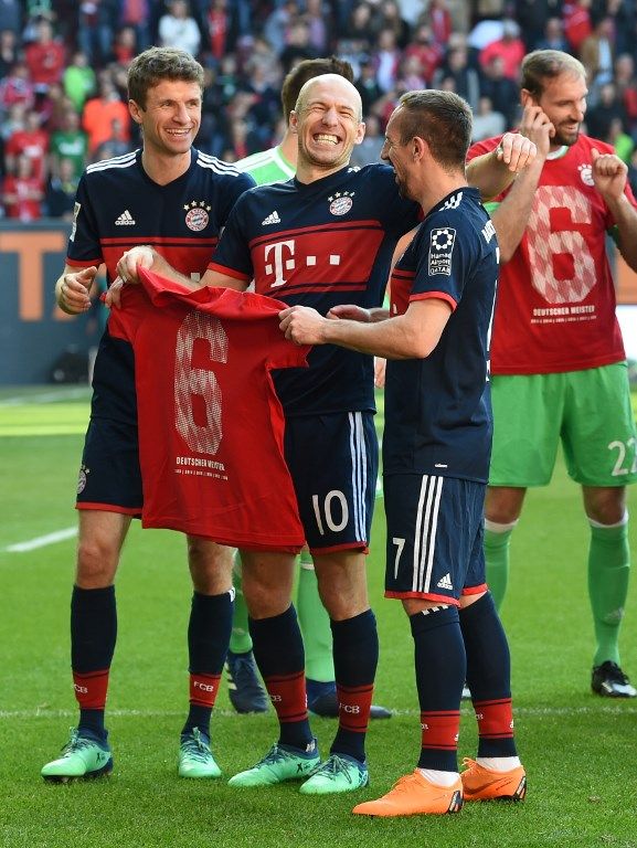 Pemain Bayern Arjen Robben (tengah) bersama dua rekannya, Franck Ribery (kanan) dan Thomas Mueller, usai memastikan gelar Bundesliga di markas Augsburg [AFP]