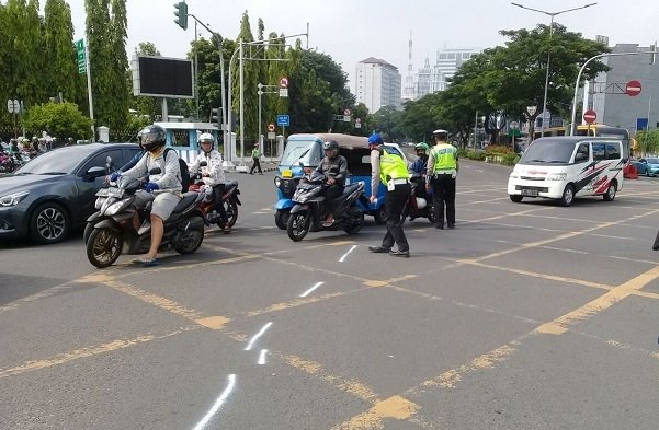 Polisi olah TKP kecelakaan model Tiara Ayu dan sopir ojek online Nur Irfan di perempatan Harmoni, Jakarta Pusat, Sabtu (14/4/2018) [suara.com/Nikolaus Tolen]