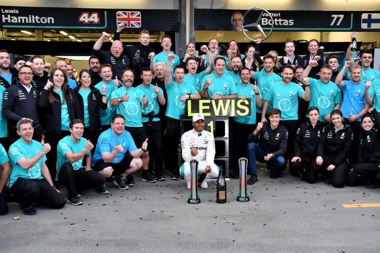 Pebalap Mercedes, Lewis Hamilton merayakan kemenangan di F1 GP Azerbaijan bersama timnya di Sirkuit Baku, Minggu (29/4/2018). [AFP/Andrej ISakovic]