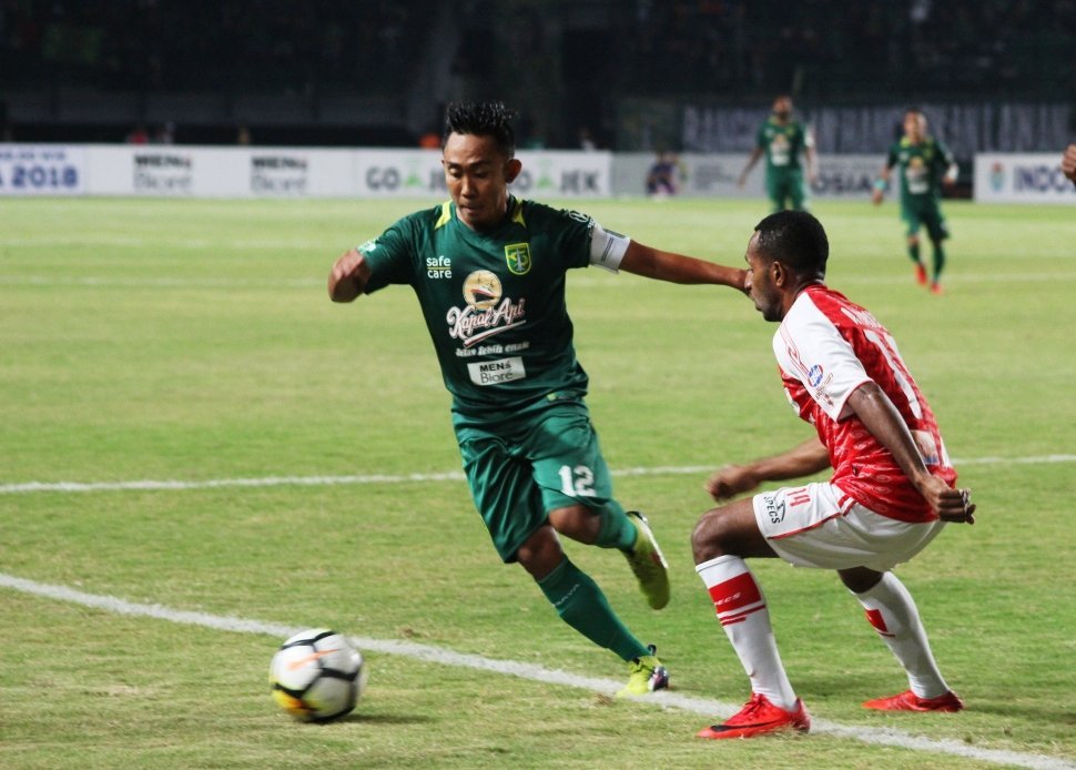 Kapten Tim Persebaya, Rendi Irwan, mencoba mengecoh bek Persipura, dipertandingan yang digelar Selasa (29/5/2018) malam [Suara.com/Dimas Angga]