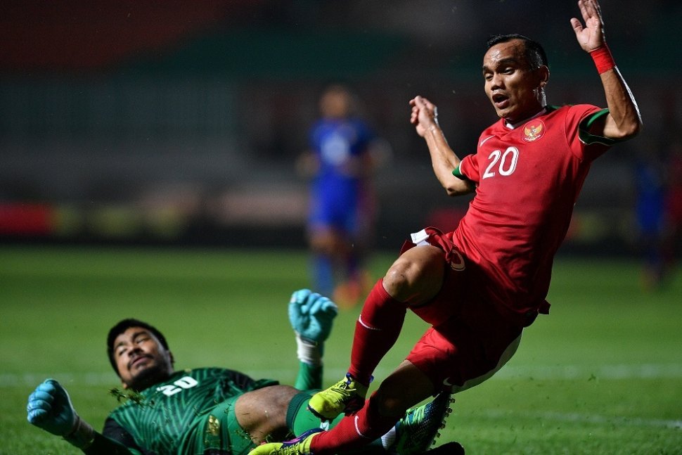 Pemain Timnas Indonesia U-23 Riko Simanjuntak (kanan) berjibaku dengan penjaga gawang Timnas Thailand U-23 Nont Muangngam dalam pertandingan uji coba di Stadion Pakansari, Cibinong, Bogor, Jawa Barat, Minggu (3/6) malam. ANTARA 