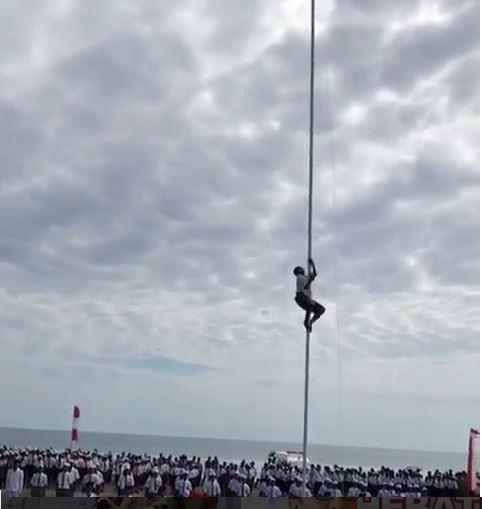 Aksi Yohanis saat menmanjat tiang bendera, karena tali bendera putus di ujung tiang. (Instagram)