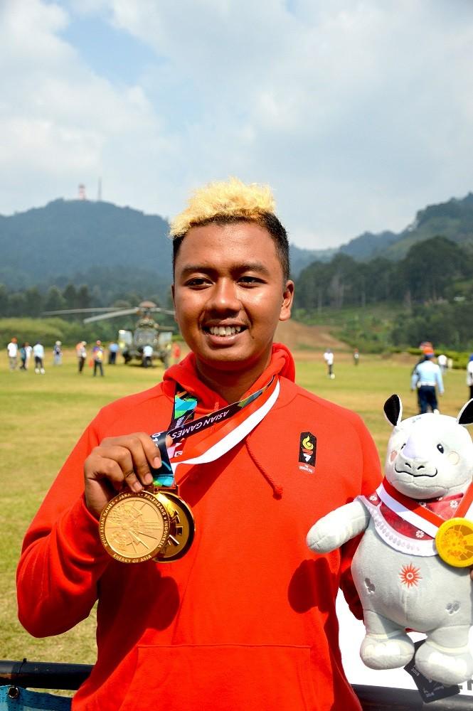 Atlet Paralayang Jafro Megawanto memperlihatkan dua medali emasnya hasil dari nomor Ketepatan Mendarat perorangan dan beregu putra Asian Games 2018 di Cisarua, Puncak, Bogor, Jawa Barat, Kamis (23/8). ANTARA FOTO/INASGOC/Tagor Siagian