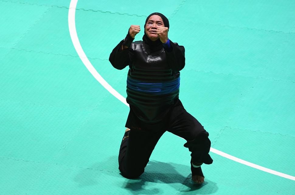 Ekspresi pesilat Indonesia Sarah Tria Monita usai mengalahkan pesilat Laos Nong Oy Vongphakdy (kiri) dalam babak final Kelas C Putri Asian Games 2018 di Padepokan Pencak Silat Taman Mini Indonesia Indah (TMII), Jakarta, Senin (27/8). ANTARA FOTO/INASGOC/Melvinas Priananda