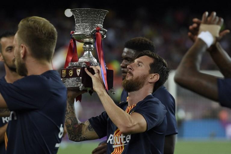 Kapten Barcelona Lionel Messi mengangkat piala Super Spanyol usai timnya mengalahkan Sevilla 2-1, 12 Agustus 2018 [AFP]