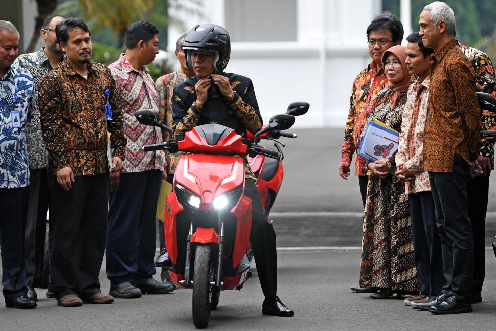 Presiden Joko Widodo mengenakan helm sebelum ANTARA FOTO/Wahyu Putro Amenjajal motor listrik buatan dalam negeri 'Gesits' seusai melakukan audiensi dengan pihak-pihak yang terkait produksi di halaman tengah Istana Kepresidenan, Jakarta, Rabu (7/11/2018). Audiensi tersebut membahas persiapan produksi massal sepeda motor listrik Gesits. [ANTARA FOTO/Wahyu Putro A].