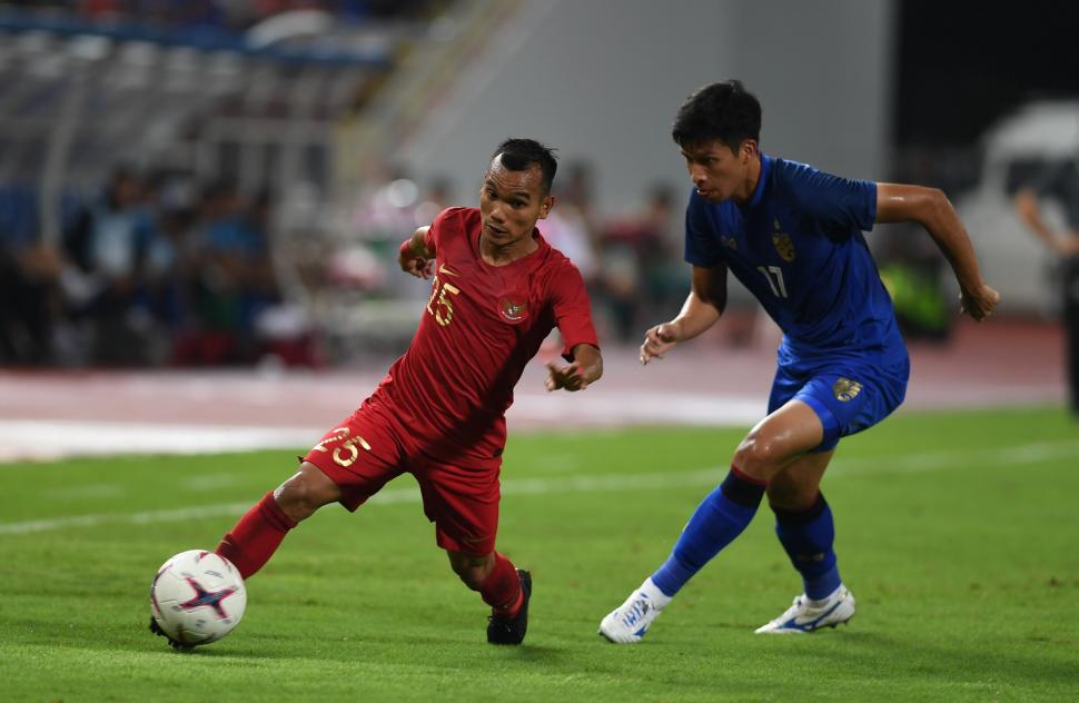 Pesepak bola Indonesia Riko Simanjuntak (kiri) berebut bola dengan pesepak bola Thailand Tanaboon Kesarat (kanan) dalam laga lanjutan Piala AFF 2018 di Stadion Nasional Rajamangala, Bangkok, Thailand, Sabtu (17/11). ANTARA FOTO/Akbar Nugroho Gumay
