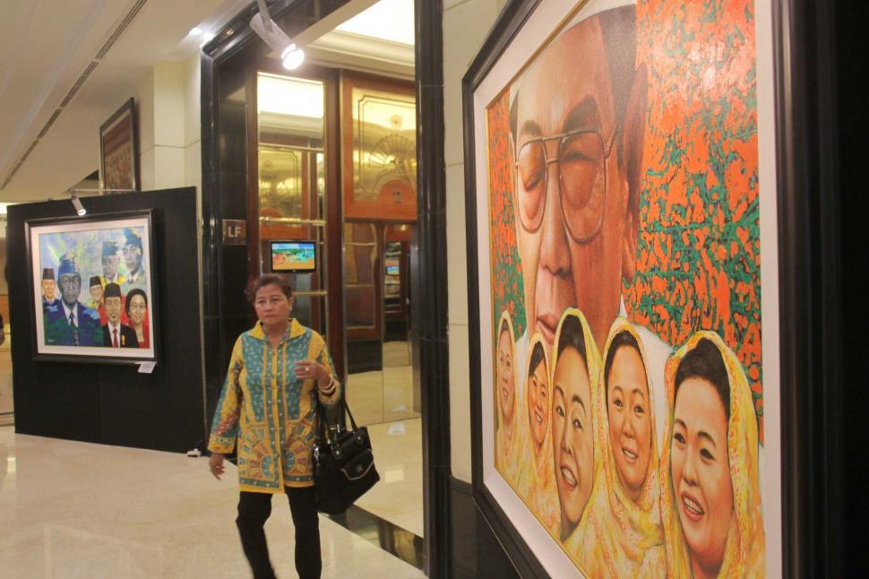 Pengunjung melihat pameran tunggal seni rupa Sang Maha Guru karya pelukis Nabila Dewi Gayatri di Senayan, Jakarta Pusat, Kamis (22/11). (Suara.com/Fakhri Hermansyah)