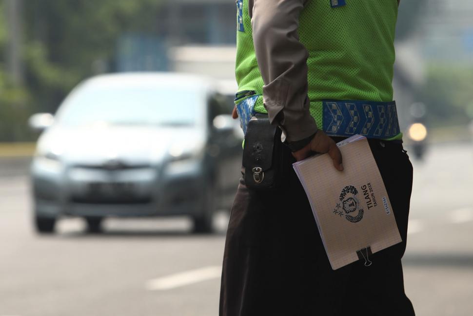 Petugas gabungan dari Badan Pajak dan Retribusi Daerah, Polisi Satuan Lalu Lintas Polda Metro, serta Jasa Raharja menggelar razia pajak di Jalan Kramat Raya, Jakarta Pusat, Kamis (22/11). [Suara.com/Muhaimin A Untung]