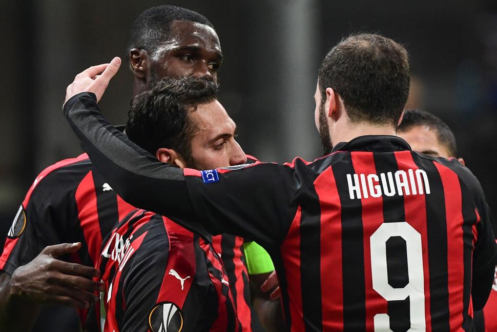 Gelandang AC Milan Hakan Calhanoglu merayakan golnya bersama Gonzalo Higuain dan Cristian Zapata,selama pertandingan Grup F Liga Europa antara AC Milan melawan Dudelange di Stadion San Siro, Milan, Italia, Jumat (30/11). .[Miguel MEDINA / AFP]