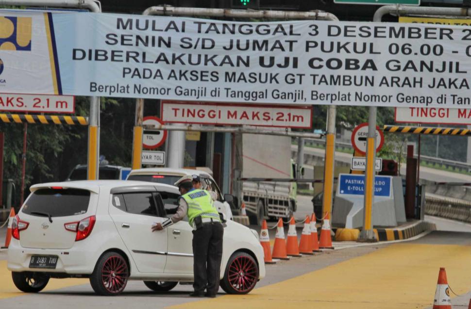 Petugas gabungan saat penerapan sistem Ganjil-Genap dari gerbang Tol Tambun di Bekasi, Jawa Barat, Selasa (4/12).(Suara.com/Fakhri Hermansyah)