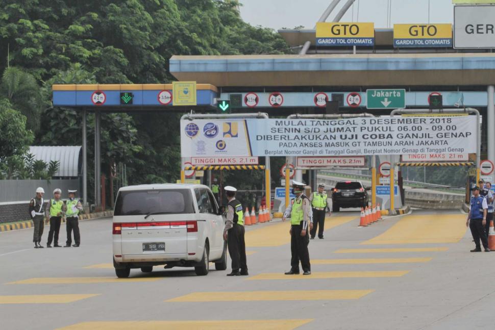 Petugas gabungan saat penerapan sistem Ganjil-Genap dari gerbang Tol Tambun di Bekasi, Jawa Barat, Selasa (4/12).(Suara.com/Fakhri Hermansyah)