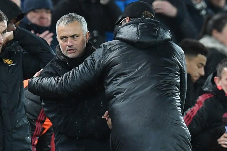 Manajer Manchester United, Jose Mourinho (kiri) menyalami manajer Liverpool, Jurgen Klopp seusai laga pekan ke-17 Liga Inggris 2018/2019 antara kedua tim di Anfield, Senin (17/12/2018) dini hari WIB. [Paul ELLIS / AFP]