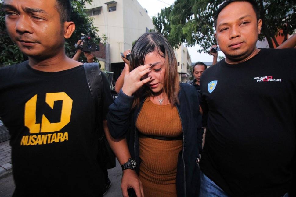 Artis berinisial AS (tengah) berjalan keluar usai menjalani pemeriksaan terkait kasus prostitusi daring di Gedung Subdit Siber Ditreskrimsus Polda Jawa Timur, Surabaya, Jawa Timur, Minggu (6/1). ANTARA FOTO/Didik Suhartono