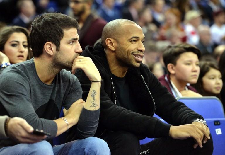 Cesc Fabregas (kiri) menyaksikan pertandingan basket di Amerika Serikat bersama Thierry Henry pada 15 Januari 2015 [AFP]