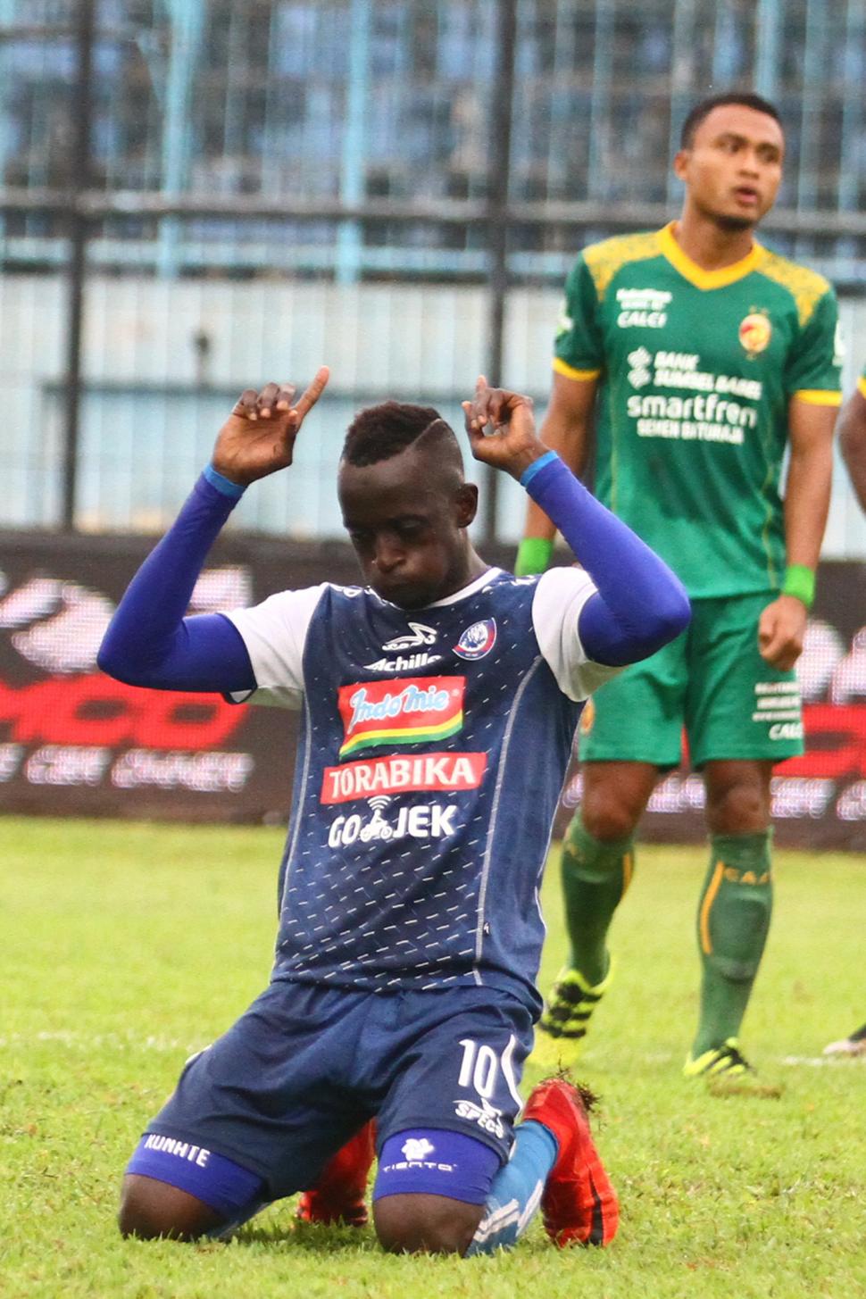 Pesepakbola Arema FC, Makan Konate (kiri) melakukan selebrasi usai mencetak gol di gawang Sriwijaya FC dalam pertandingan Liga I GOJEK di Stadion Kanjuruhan, Malang, Jawa Timur, Minggu (9/12/2018). Arema FC mengalahkan Sriwijaya FC dengan skor akhir 2-1. ANTARA FOTO/Ari Bowo Sucipto