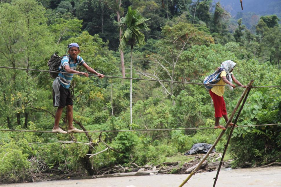 Warga menyeberangi sungai Krueng Meureubo dengan menggunakan jembatan tali yang terbuat dari kabel listrik menuju Desa Sikundo, Kecamatan Pante Ceureumen, Aceh Barat, Aceh, Sabtu (2/1). ANTARA FOTO/Syifa Yulinnas