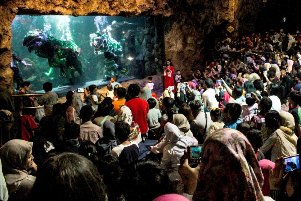 Pengunjung menyaksikan pertunjukan barongsai di dalam air di Seaworld Ancol, Jakarta, Minggu (3/2). ANTARA FOTO/Putra Haryo Kurniawan