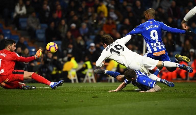 Pemain Real Madrid, Alvaro Odriozola (seragam putih) menyundul bola dalam laga kontra Alaves di lanjutan kompetisi La Liga, Senin dini hari WIB (4/2). [AFP/Gabriel Bouys]