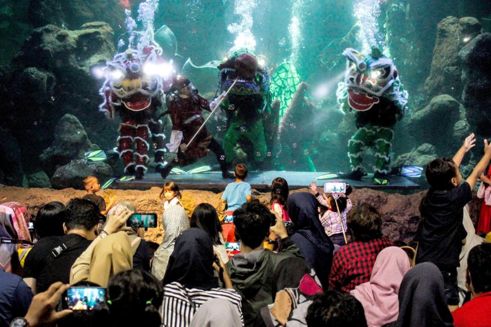 Pengunjung menyaksikan pertunjukan barongsai di dalam air di Seaworld Ancol, Jakarta, Minggu (3/2). ANTARA FOTO/Putra Haryo Kurniawan
