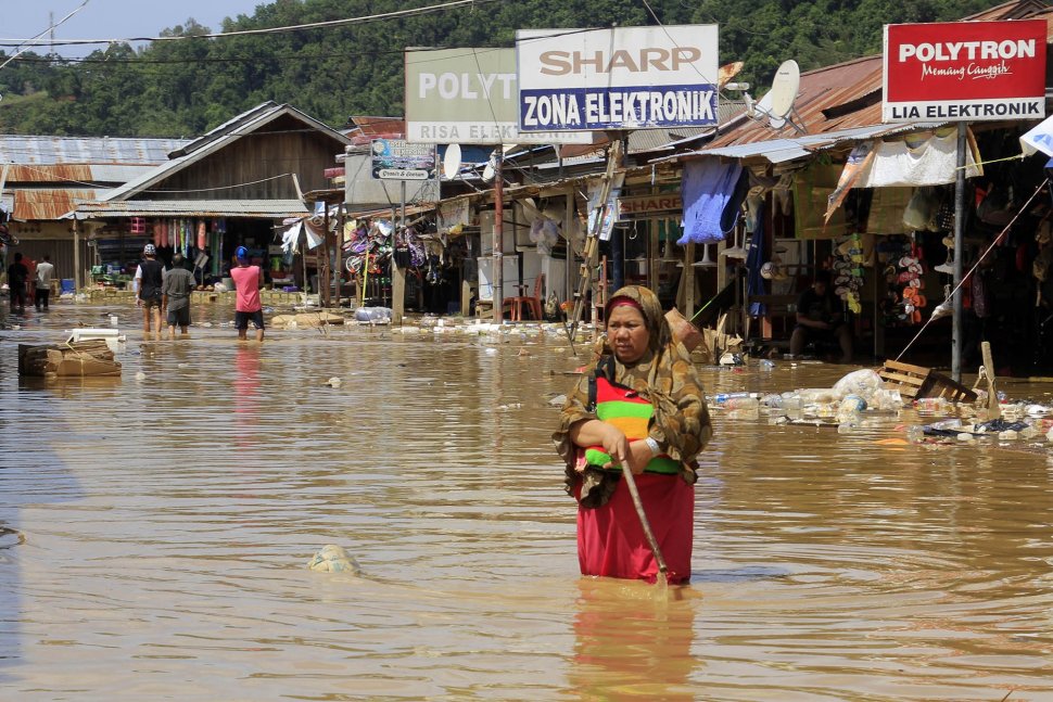Warga melintas saat banjir merendam kompleks Pasar Youtefa, Abepura, Jayapura, Papua, Sabtu (23/2/2019). Hujan deras yang terjadi sejak Jumat (22/2). ANTARA FOTO/Gusti Tanati