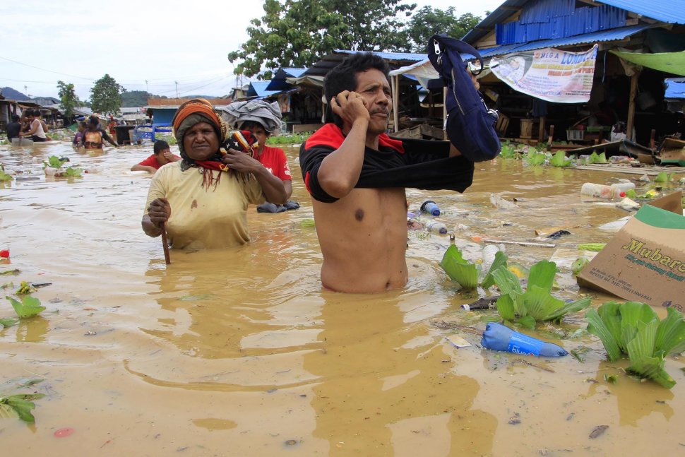 Sejumlah warga melintas saat banjir merendam kompleks Pasar Youtefa, Abepura, Jayapura, Papua, Sabtu (23/2). ANTARA FOTO/Gusti Tanati/sgd/foc.