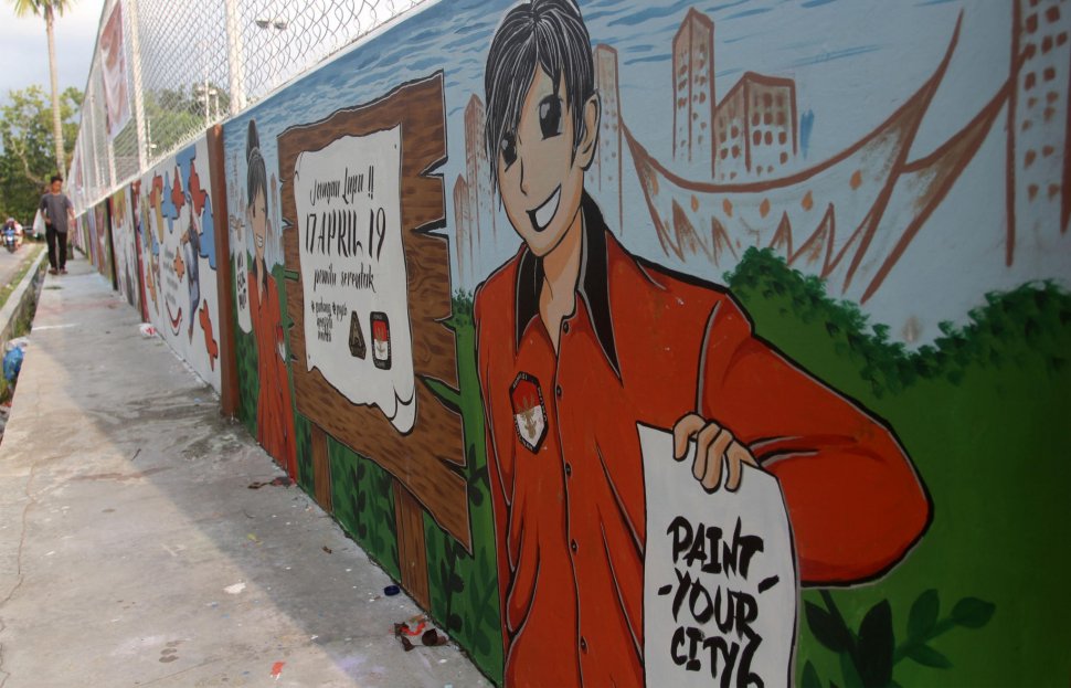 Sejumlah warga memperhatikan mural bertema Pemilu 2019 di Kawasan Gor Haji. Agus Salim Padang, Sumatera Barat, Minggu (3/3). ANTARA FOTO/Muhammad Arif Pribadi