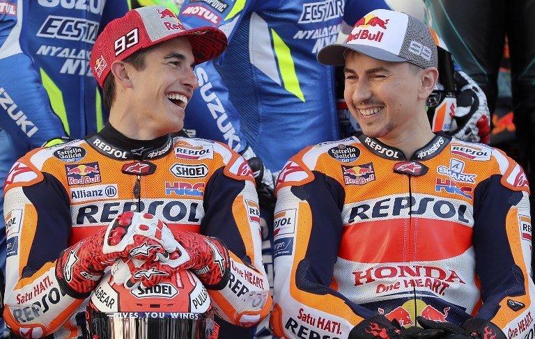 Duet pebalap Repsol Honda, Marc Marquez (kiri) dan Jorge Lorenzo, berfoto bersama jelang dimulainya seri perdana MotoGP 2019 di Sirkuit Losail, Qatar, Kamis (7/3/2019). [AFP/Karim Jaafar]