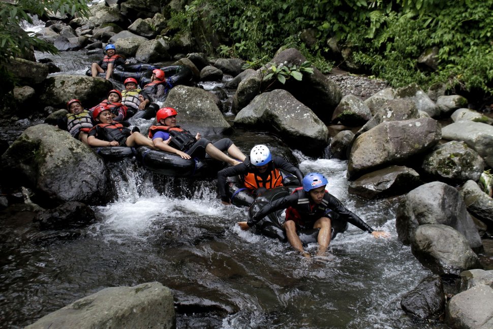 Wisatawan menikmati wisata tubing atau menyusuri sungai memanfaatkan ban dalam mobil yang digelar Sukabumi Getlost di Sungai Cipelang, Sukabumi, Jawa Barat, Kamis (14/3). ANTARA FOTO/Budiyanto