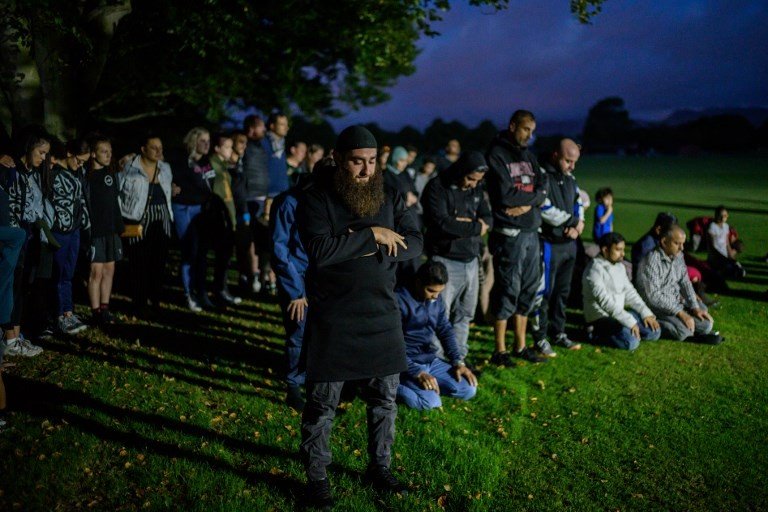 Rabu (20/3) malam, warga Christchurch membentuk pagar betis mengelilingi jemaah salat Magrib di depan Masjid Al Noor. [Anthony Wallace/AFP]