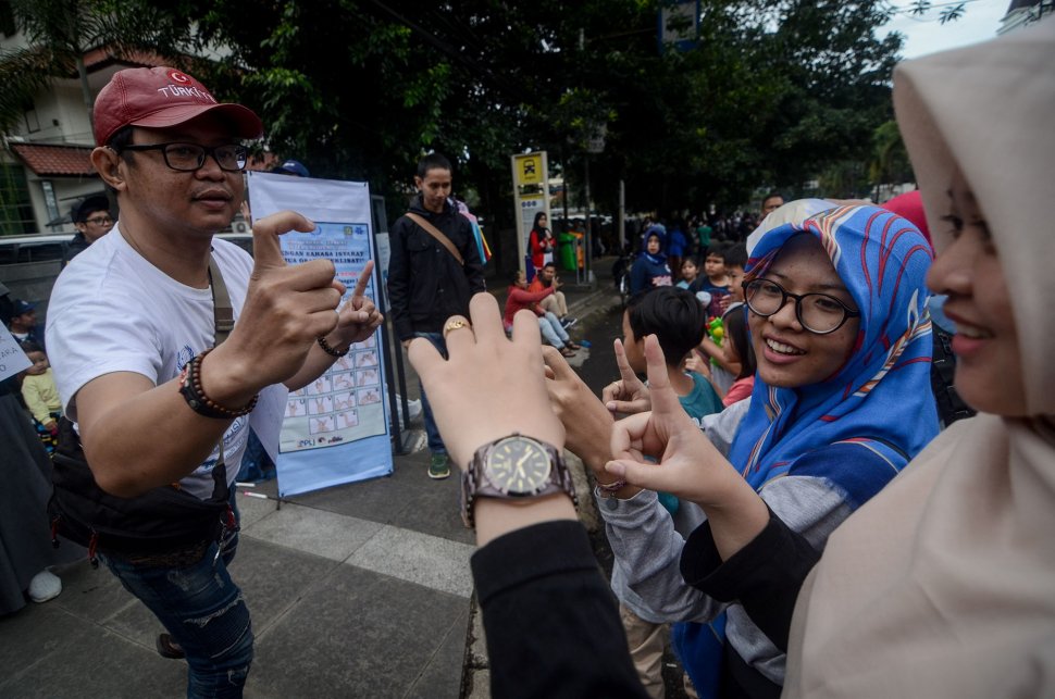 Seorang pegiat sosial melakukan sosialisasi bahasa isyarat saat Hari Bebas Kendaraan Bermotor (HBKB) di Dago, Bandung, Jawa Barat, Minggu (24/3). ANTARA FOTO/Raisan Al Farisi