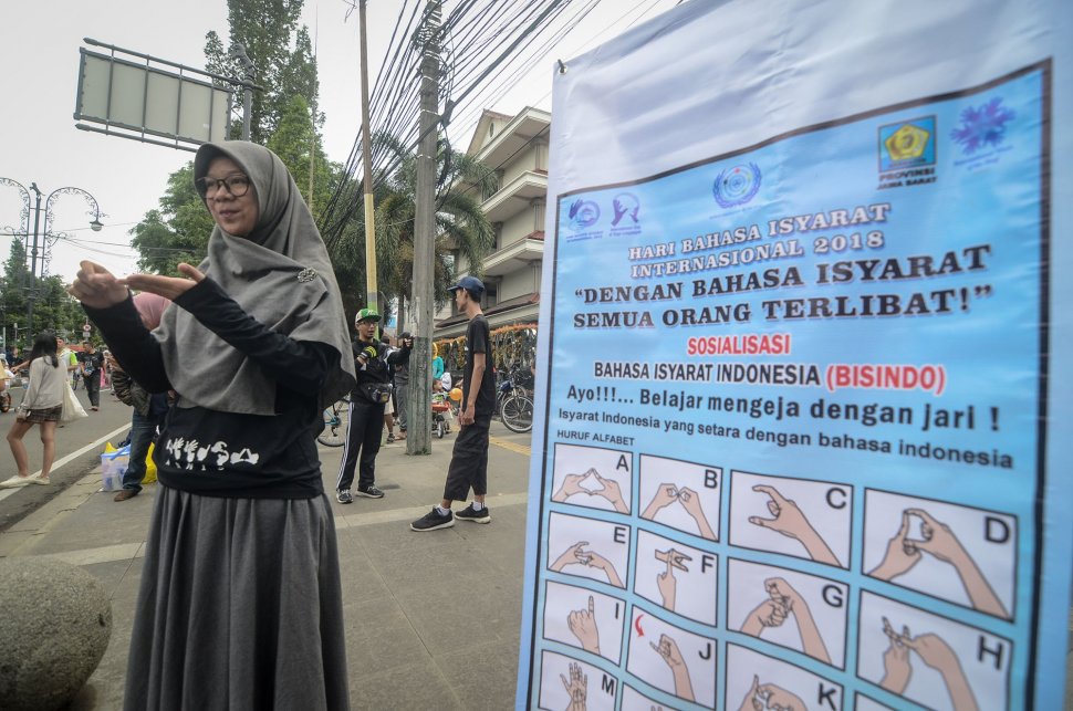 Seorang pegiat sosial melakukan sosialisasi bahasa isyarat saat Hari Bebas Kendaraan Bermotor (HBKB) di Dago, Bandung, Jawa Barat, Minggu (24/3). ANTARA FOTO/Raisan Al Farisi