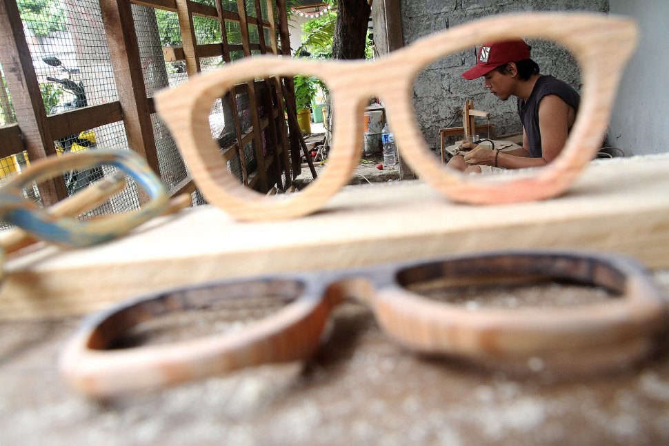 Pengrajin menyelesaikan pembuatan kacamata berbahan baku kayu di Jalan Salak 8, Pondok Benda, Pamulang, Tangerang Selatan, Senin (25/3). [Suara.com/Arief Hermawan