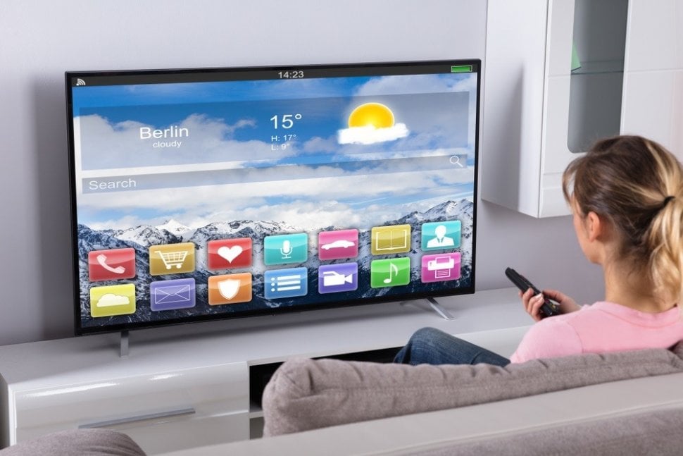 Ilustrasi seorang perempuan mencoba Smart TV. [Shutterstock]