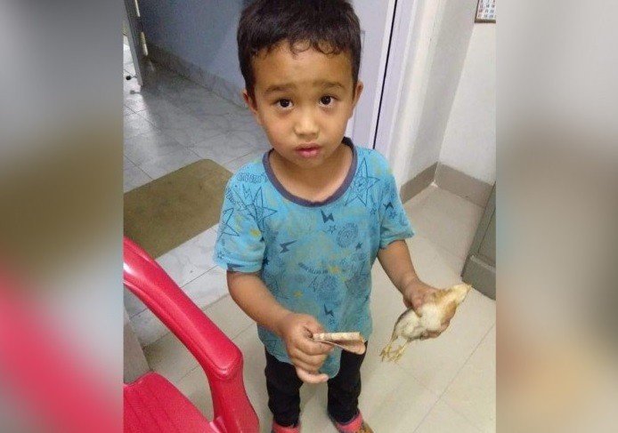 Derek C Lalchhanhima saat membawa anak ayam yang mati tertabrak sepedanya ke dokter. [Facebook]