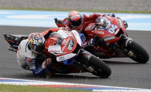 Pebalap tim satelit Ducati, Jack Miller (kiri), mencoba melewati rider utama Ducati, Andrea Dovizioso, saat sesi kualifikasi MotoGP Argentina, Sabtu (30/3/2019). [AFP/Juan Mabromata]