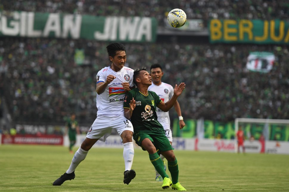 Pesepak bola Persebaya Surabaya Irfan Jaya (kanan) berebut bola di udara dengan pesepak bola Arema FC Jayus Hariono pada laga final leg 1 Piala Presiden 2019 di Gelora Bung Tomo, Surabaya, Jawa Timur, Selasa (9/4/2019). Pertandingan tersebut berakhir imbang dengan skor 2-2. ANTARA FOTO/Zabur Karuru