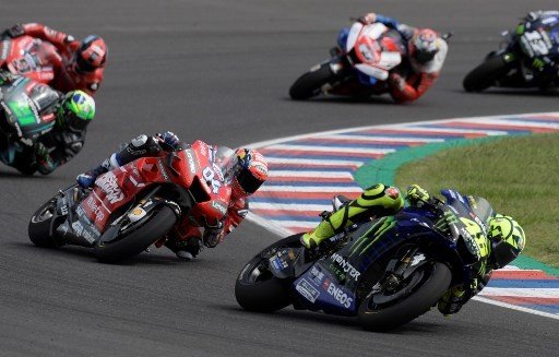 Pebalap Ducati Andrea Dovizioso menguntit kompatriotnya dari Italia, Valentino Rossi (Yamaha), saat balapan MotoGP Argentina di Autodromo Termas de Rio Hondo, Minggu (31/4/2019). [AFP/Juan Mabromata]