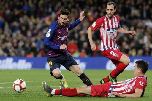 Pemain Barcelona Lionel Messi memperdayai dua pemain Atletico Madrid dalam lanjutan La Liga yang berlangsung di Camp Nou, 7 April 2019 [AFP]