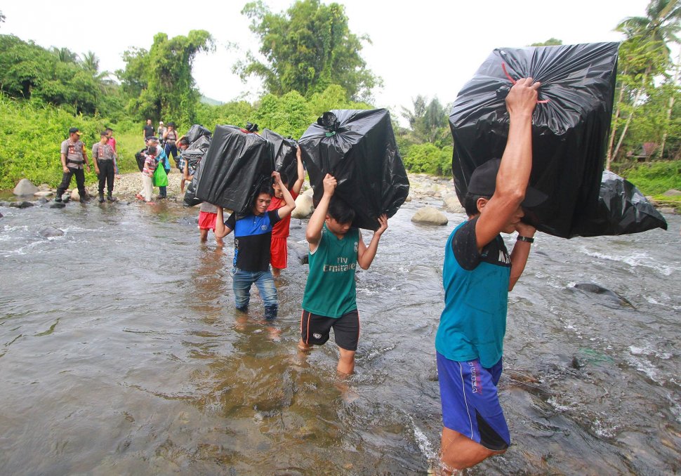 Sejumlah pekerja pengangkut barang (porter) menyeberangi sungai saat membawa logistik Pemilu serentak 2019 ke dua desa terpencil di kaki Pegunungan Meratus, Kabupaten Hulu Sungai Tengah, Kalimantan Selatan, Minggu (14/4). ANTARA FOTO/Bayu Pratama S